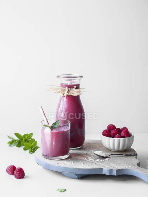 Pink liquorice and raspberry smoothie served in a glass and carafe — Stock Photo