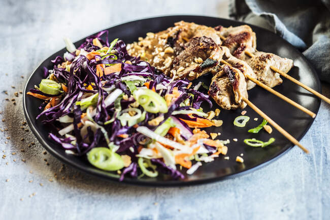 Sate skewers with peanut sauce and red cabbage salad in Thai style — Stock Photo