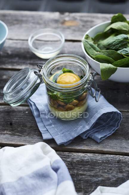 An egg in a glass: layered ingredients in a flip-top glass jar — Stock Photo