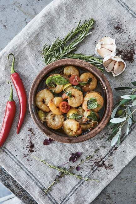Knoblauchgarnelen mit Tomaten und frischen Kräutern in rustikalem Serviergericht — Stockfoto