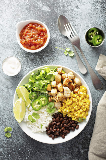 Comida mexicana con pollo, arroz, frijoles negros y maíz - foto de stock