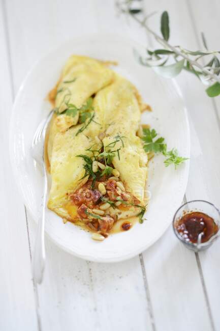 Omelette stuffed with pine nuts and herbs — Stock Photo