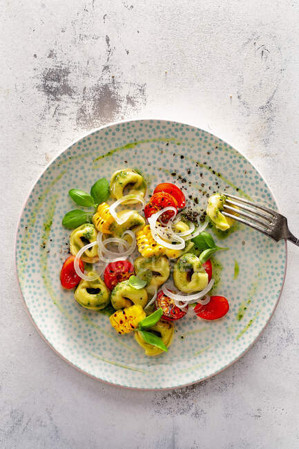 Tortellini with cocktail tomatoes, grilled corn and basil pesto — Stock Photo