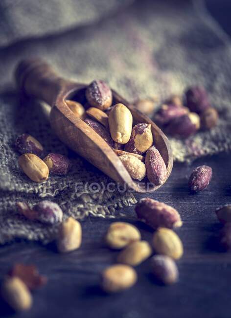 Um arranjo de amendoins salgados e torrados em uma colher de madeira — Fotografia de Stock