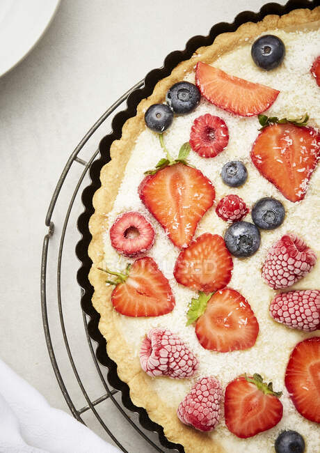 Kuchen mit Erdbeeren, Blaubeeren, gefrorenen Himbeeren und Kokosstreusel — Stockfoto