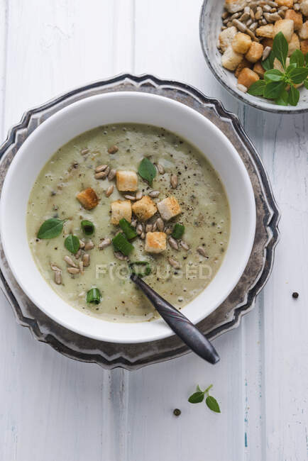 Vegan potato and basil cream soup with croutons and roasted sunflower seeds — Stock Photo