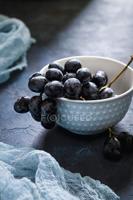 Bol en céramique bleue de raisins rouges — Photo de stock