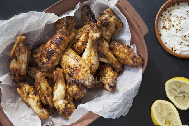 Baked chicken wings with lemon and dip — Stock Photo