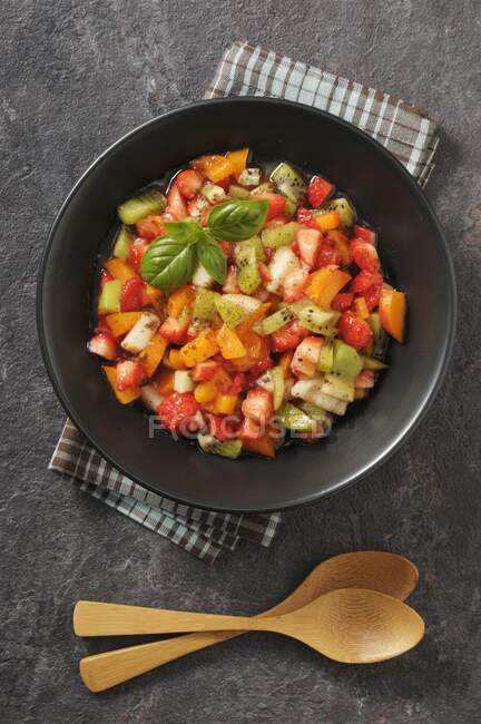 Fruit salad with strawberries, apricots, peaches, kiwi and basil — Stock Photo