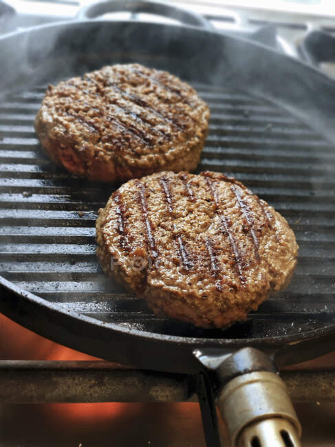 Burger patties in a grill pan — Stock Photo