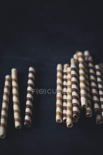 Biscuits roulés gaufres sur une surface sombre — Photo de stock