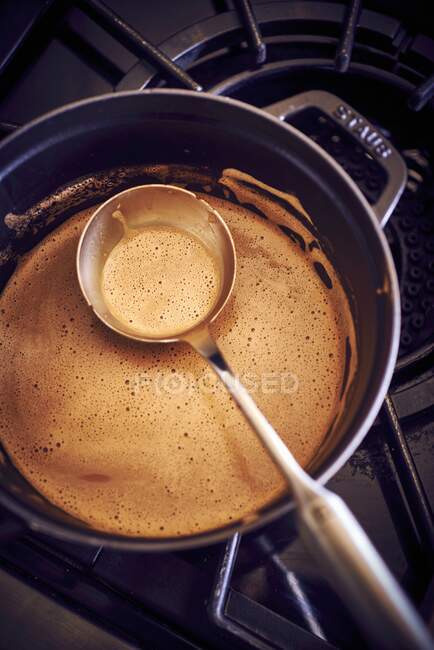 Close-up shot of delicious Hot chocolate in a saucepan on a stove — Stock Photo