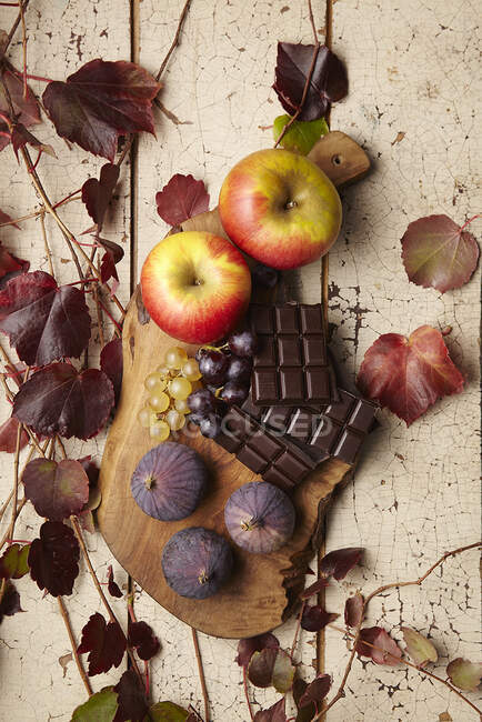 An autumnal arrangement of apples, figs, grapes and chocolate — Stock Photo