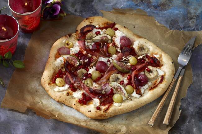 Uma pizza doce com figos, uvas, sementes de banana e romã — Fotografia de Stock