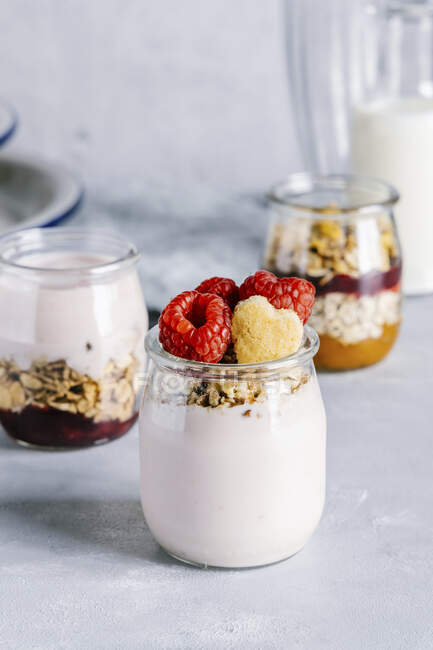 Healthy raspberry parfaits with yogurt in glass jars — Stock Photo