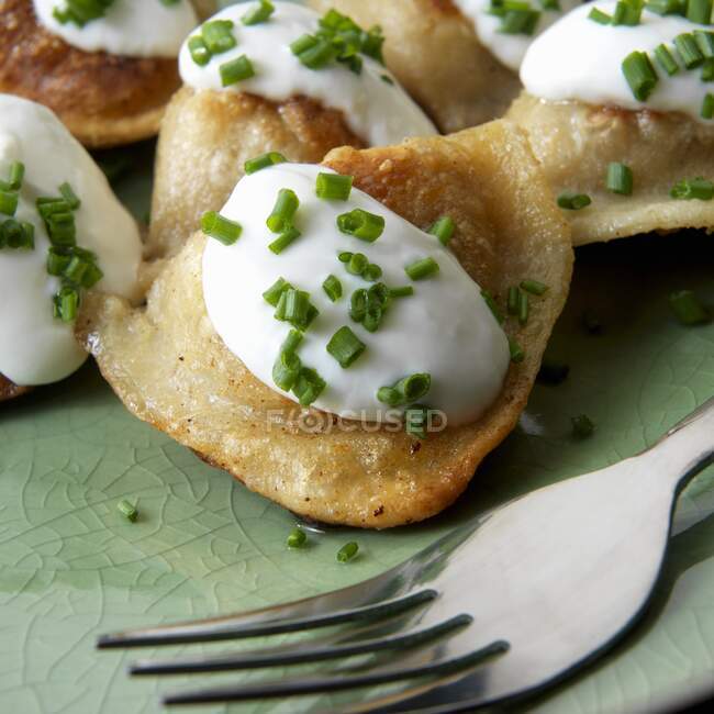 Potato filled pierogies (Pirogi) with sour cream and chives clos — Stock Photo