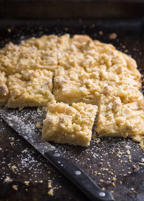 Vegan pudding crumble cake from the tray with apples and almonds — Stock Photo