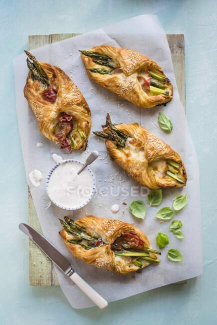 Puff pastry pockets filled with asparagus wrapped in Parma ham, mozzarella and pesto, served with a mustard dip — Stock Photo