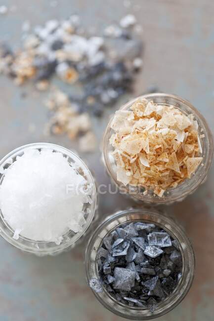 Black salt, paprika salt and sea salt flakes in glasses — Stock Photo