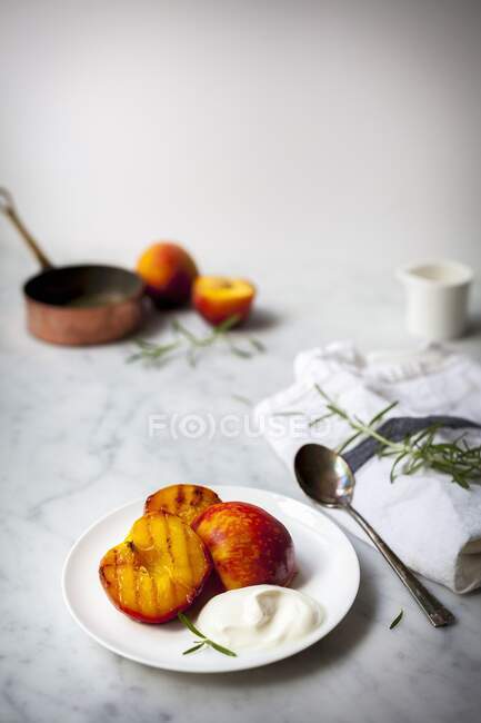 Персики на гриле с йогуртом и розмарином, здоровый десерт — стоковое фото