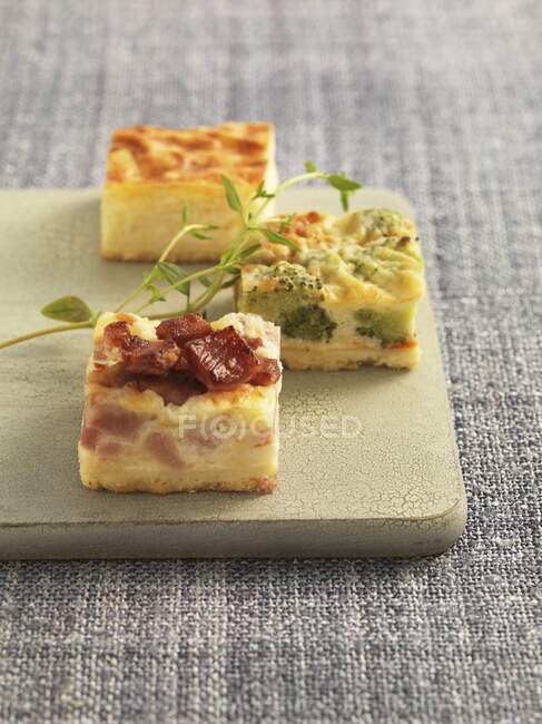 Various quiche appetisers on a chopping board — Stock Photo
