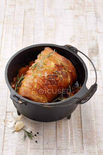 Rolled roasted pork belly in Dutch oven cooking pot — Stock Photo
