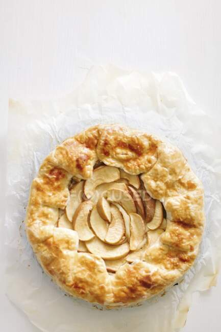 Galette with apples and cinnamon on parchment paper — Stock Photo