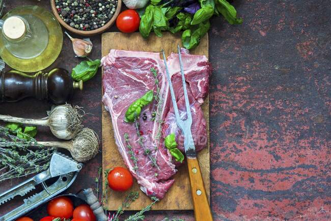 Raw T-bone steak avec différents ingrédients — Photo de stock