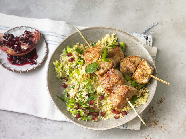 Oriental chicken kebab with couscous and pomegranate seeds — Stock Photo
