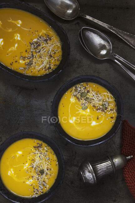 Sweet potato and carrot soup topped with seeds — Stock Photo