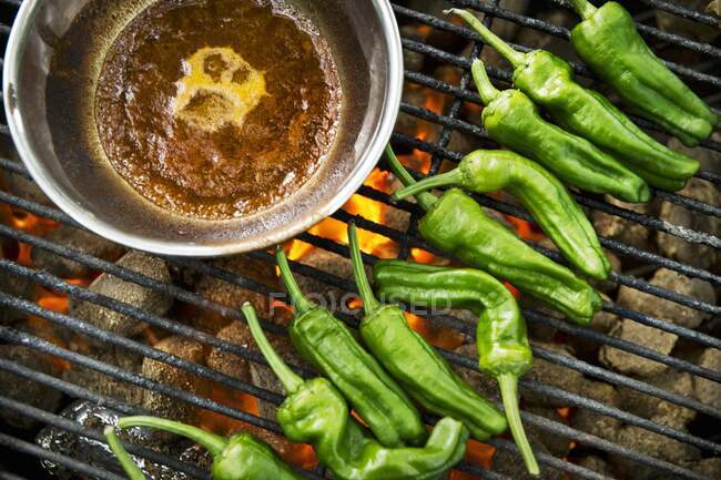 Green chilli peppers on a grill — Stock Photo