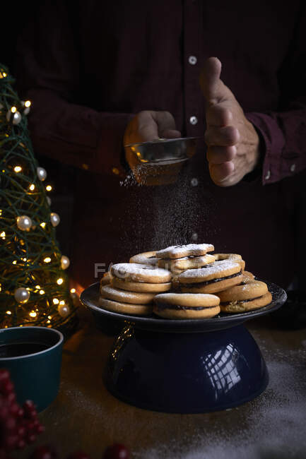 Biscotti Linzer appena sfornati che vengono spolverati di zucchero — Foto stock