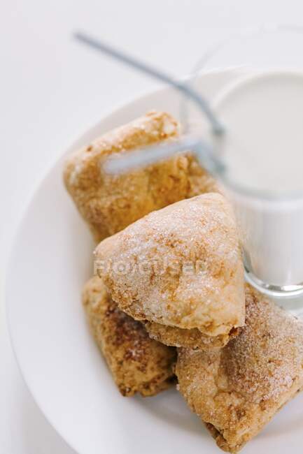 Печенье из творога на белой тарелке с молоком — стоковое фото
