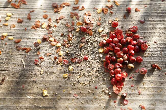 Whole pink peppercorns, ground black pepper and chilli flakes — Stock Photo