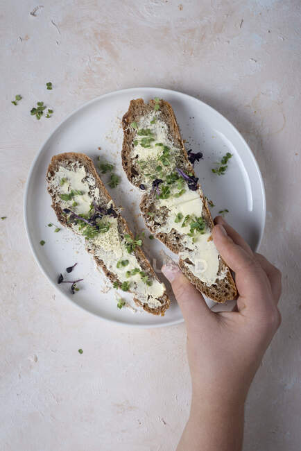 Two slices of sourdough bread with butter and cress — Stock Photo