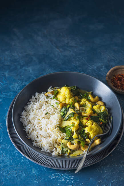 Vegan indian cauliflower and cashew nuts curry with spinach and rice — Stock Photo