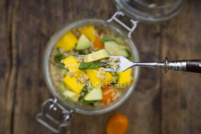 Salade de quinoa avec avocat, concombre, tomate et mangue dans un bocal en verre — Photo de stock