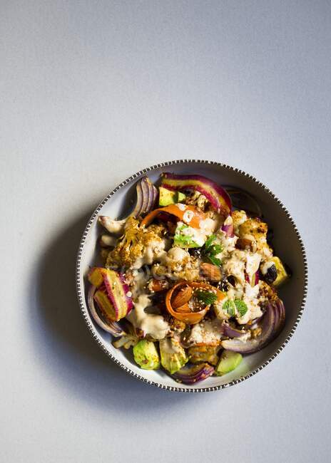 Вегетарианский салат с жареными овощами, харисса и заправка тахини — стоковое фото