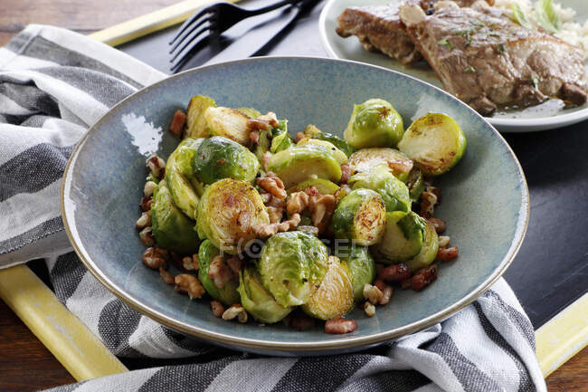Brussels sprouts fried with bacon and nuts — Stock Photo