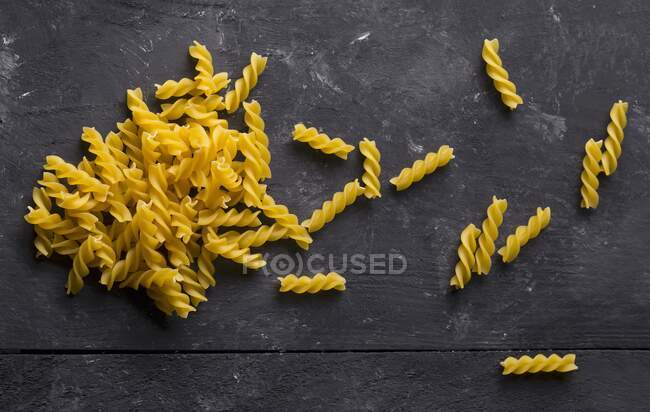 Getrocknete Spirelli-Pasta auf schwarzem Hintergrund — Stockfoto