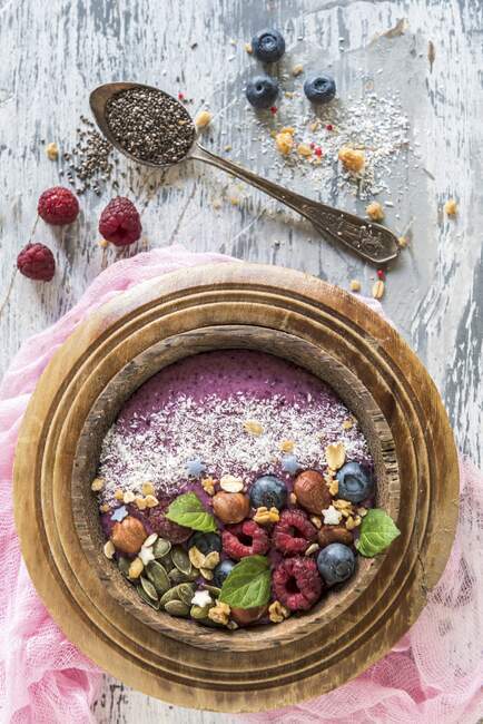Berry smoothie bowl with hazelnuts, pumpkin seeds and oat flakes — Stock Photo