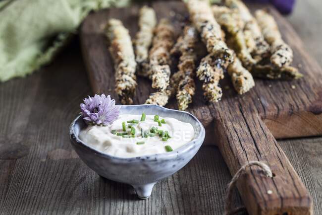 Fried breaded asparagus with almond flour and sesame seeds, and a herb dip — Stock Photo