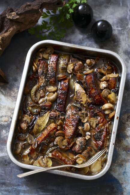 Spare ribs with mushrooms in casserole dish — Stock Photo