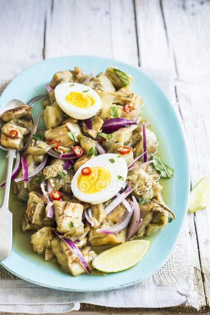 Fried aubergines salad with chillies, onion and egg halves — Stock Photo