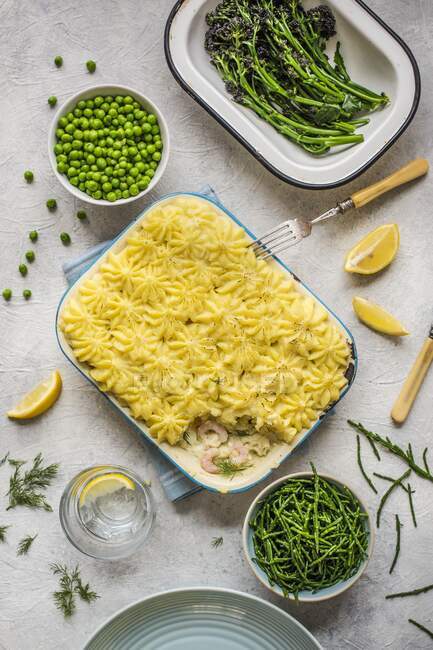 Fish pie with vegetable side dishes — Stock Photo