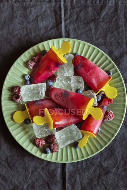 Ice lollies with raspberries and blueberries — Stock Photo