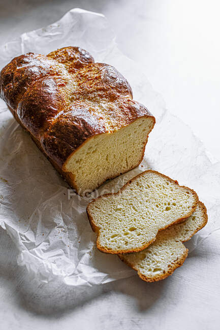 Delizioso pane fresco fatto in casa su sfondo di legno bianco — Foto stock