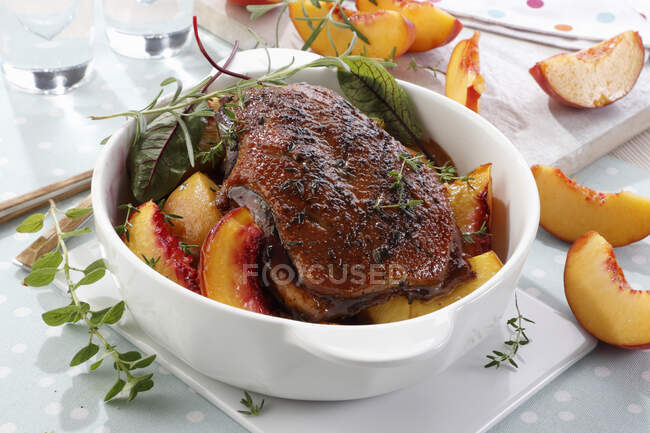 Baked goose breast in a sauce with pieces of peaches — Stock Photo
