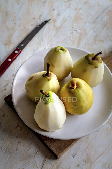 Pears on a plate on a wooden background — Stock Photo