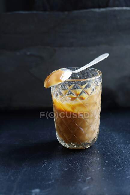 Molho de caramelo em um jarro de engarrafamento com um colher de chá no topo — Fotografia de Stock